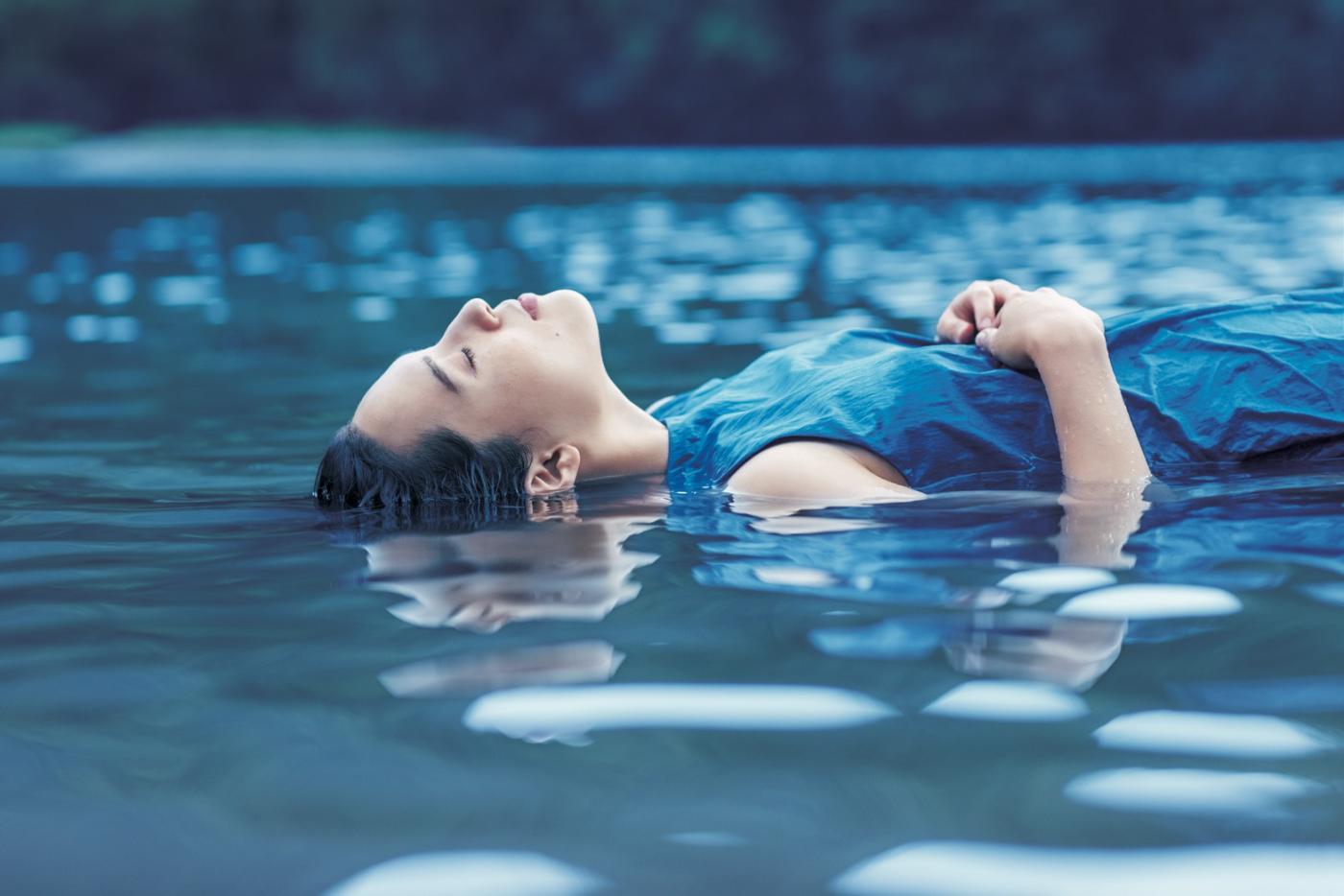 水に浮かび、静かに目を閉じる女性